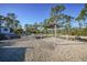 Gravel backyard with shade sail and pathway to a wooded area at 489 & 497 Campbell St, Port Charlotte, FL 33953