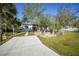 Modern home with paved driveway and landscaped front yard, featuring palm trees at 489 & 497 Campbell St, Port Charlotte, FL 33953