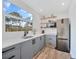 Modern kitchen with gray cabinets, quartz countertops and a window overlooking the backyard at 489 & 497 Campbell St, Port Charlotte, FL 33953