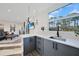 Modern kitchen with gray cabinets, quartz countertops and a view into the living room at 489 & 497 Campbell St, Port Charlotte, FL 33953