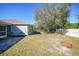 Backyard view showing a patio area, mature tree, and a fenced yard at 4959 Cromey Rd, North Port, FL 34288