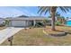 Single story home exterior showcasing front yard landscaping and driveway at 498 E Tarpon Nw Blvd, Port Charlotte, FL 33952