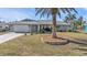 Single-story home with palm tree, landscaped yard, and attached garage at 498 E Tarpon Nw Blvd, Port Charlotte, FL 33952