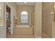 Bathroom with a large soaking tub, glass shower, and neutral tile at 5189 Collingswood Blvd, Port Charlotte, FL 33948