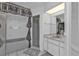 Bright bathroom features a combination shower and tub, plus a white vanity with mirror and white cabinets at 5194 Fleming St, Port Charlotte, FL 33981