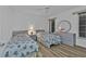 Cozy bedroom featuring two twin beds, wood-look tile flooring, and a round mirror on the dresser at 5194 Fleming St, Port Charlotte, FL 33981