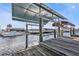 View of a covered boat lift and canal-front property with boats docked nearby at 5194 Fleming St, Port Charlotte, FL 33981