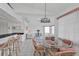 Open-concept dining area with glass table, pink cushioned chairs, and counter seating, offering a view of the living room at 5194 Fleming St, Port Charlotte, FL 33981