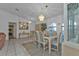 Well-lit dining room with tiled flooring under table and hardwood under the rest features a hanging light fixture at 5194 Fleming St, Port Charlotte, FL 33981