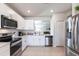 Modern kitchen with white cabinets, stainless steel appliances and quartz countertops at 5277 Shell Mound Cir, Punta Gorda, FL 33982