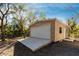 Tan detached garage with white door and single window at 5301 Sabal Palm Ln, Punta Gorda, FL 33982