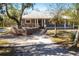 Gray house with wood deck and stone pathway, surrounded by lush trees at 5301 Sabal Palm Ln, Punta Gorda, FL 33982