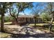 Gray house with wood deck and stone pathway, surrounded by lush trees at 5301 Sabal Palm Ln, Punta Gorda, FL 33982