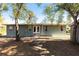 Rear view of a single-story house with double doors and mature trees at 5301 Sabal Palm Ln, Punta Gorda, FL 33982