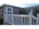 Mobile home with a deck featuring a white railing and seating area at 6671 Keystone Ct, North Port, FL 34287