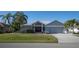 Single-story home with gray siding, red door, and palm trees at 7233 N Plum Tree, Punta Gorda, FL 33955