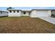 Single-story house with white exterior, attached garage, and grassy front yard at 85 Snedeker St, Port Charlotte, FL 33954