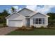 One-story home with gray siding, white garage door, and landscaping at 9525 Turtle Grass Cir, Punta Gorda, FL 33950