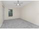 Bright bedroom with grey carpet, double closet, and ceiling fan at 121 Cambridge Nw Dr, Port Charlotte, FL 33952