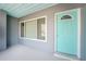 Enclosed porch with light teal door and tiled floor at 121 Cambridge Nw Dr, Port Charlotte, FL 33952