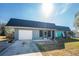 Ranch-style home with teal accents and metal roof at 121 Cambridge Nw Dr, Port Charlotte, FL 33952