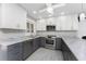 Renovated kitchen with gray and white cabinets and granite countertops at 121 Cambridge Nw Dr, Port Charlotte, FL 33952