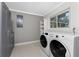 Bright laundry room with washer, dryer, and shelving at 121 Cambridge Nw Dr, Port Charlotte, FL 33952