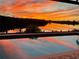 Stunning sunset view reflected in the pool water at 1454 Surfbird Ct, Punta Gorda, FL 33950