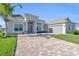 One-story home with gray tile roof and paver driveway at 15100 River Birch Ct, Punta Gorda, FL 33955