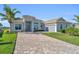 One-story home with gray tile roof and paver driveway at 15100 River Birch Ct, Punta Gorda, FL 33955