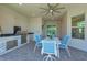 Outdoor kitchen with stainless steel appliances and seating area at 15100 River Birch Ct, Punta Gorda, FL 33955