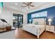 Main bedroom with blue accent wall, white bed, and access to patio at 17138 Anthem Ln, Punta Gorda, FL 33955