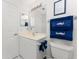 Simple bathroom with white vanity and blue nautical-themed towels at 17521 Pomegrante Way, Punta Gorda, FL 33955