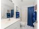 Clean bathroom with white vanity, blue shower curtain, and nautical towels at 17521 Pomegrante Way, Punta Gorda, FL 33955