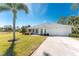 Single-story home with attached garage, palm tree, and landscaped lawn at 17521 Pomegrante Way, Punta Gorda, FL 33955