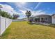 Large backyard with screened patio, grassy area, and white vinyl fence at 1824 Dawnview St, North Port, FL 34288