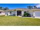 Single-story home with a well-manicured lawn and attached garage at 1824 Dawnview St, North Port, FL 34288