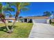 House with a palm tree in front and a driveway at 1824 Dawnview St, North Port, FL 34288