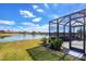 Lakefront backyard with a screened patio at 1840 Bobcat Trl, North Port, FL 34288