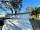 Three-car garage, light green house, long driveway at 18506 Klingler Cir, Port Charlotte, FL 33948