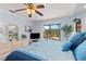 A bedroom with a ceiling fan, light blue walls, and a view of the pool at 2149 Rio De Janeiro Ave, Punta Gorda, FL 33983