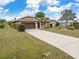 Exterior view of home with a well-maintained lawn, two car garage, and desert landscaping at 2149 Rio De Janeiro Ave, Punta Gorda, FL 33983