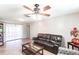 Living room with tile floors, leather sofa, and ceiling fan at 22498 Westchester Blvd, Punta Gorda, FL 33980