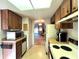 Galley kitchen with wood cabinets and appliances at 2395 Harbor Blvd # 324B, Port Charlotte, FL 33952