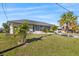 Single-story home with gray exterior, landscaping, and palm trees at 312 E Tarpon Nw Blvd, Port Charlotte, FL 33952