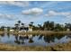 Single-Gathering home on a lake with palm trees and lush landscaping at 316 Antis Dr, Rotonda West, FL 33947