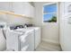 Bright laundry room with washer, dryer, and ample cabinet space at 3307 Dominica Ct, Punta Gorda, FL 33950