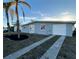 Gray house with a two-car garage and palm trees in the front yard at 4127 Gardner Dr, Port Charlotte, FL 33952