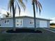 Newly renovated home with gray exterior, double doors, and palm trees at 4127 Gardner Dr, Port Charlotte, FL 33952