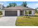 Newly constructed home with a two-car garage and well-manicured lawn at 509 Sunset N Rd, Rotonda West, FL 33947